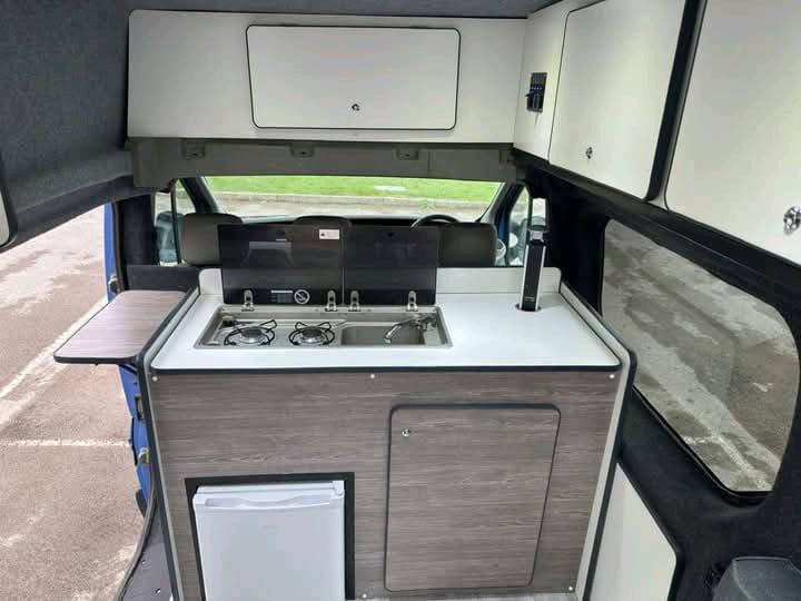 Extra storage cabinet beneath campervan cooker