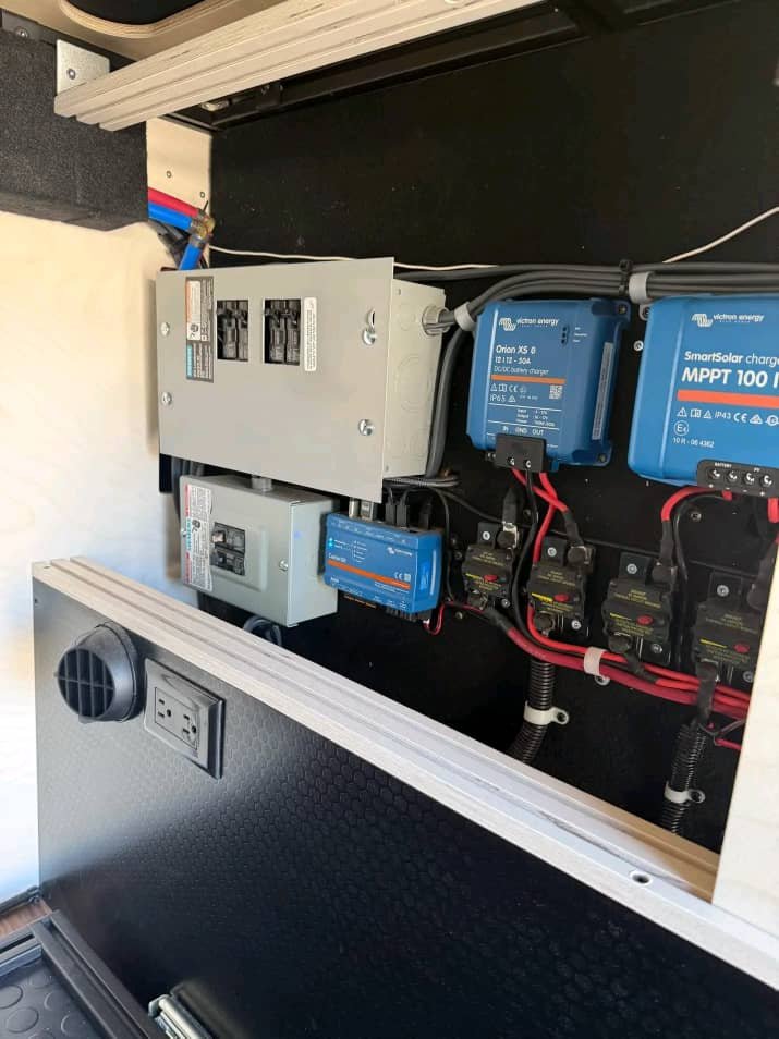 Electrical power distribution panel and wiring system inside a Sprinter 2500 passenger van.