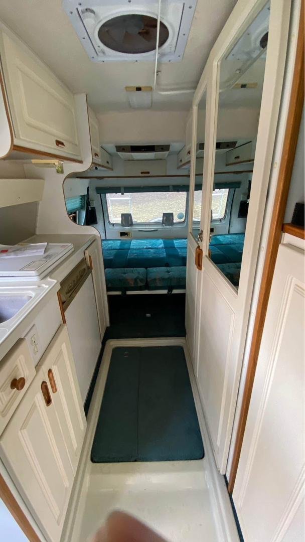 Kitchen area with sink, stove, and microwave in Leisure Travel Widebody