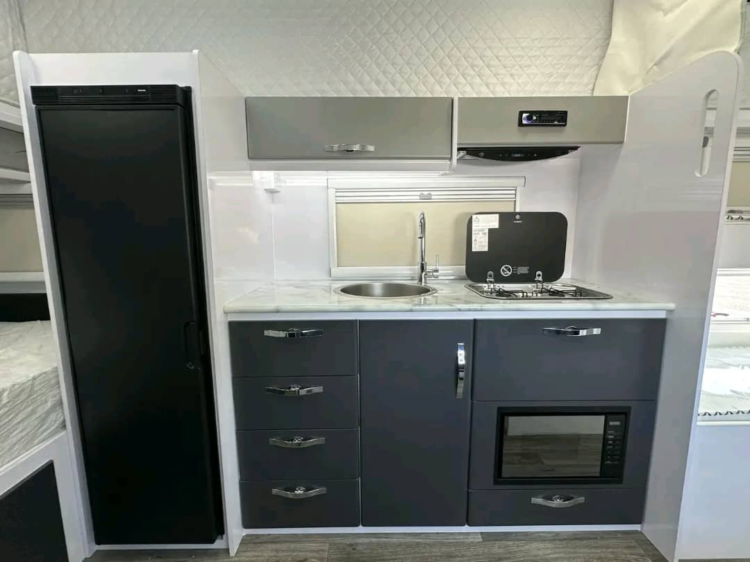 Kitchen area with stainless sink, stove, fridge, and microwave