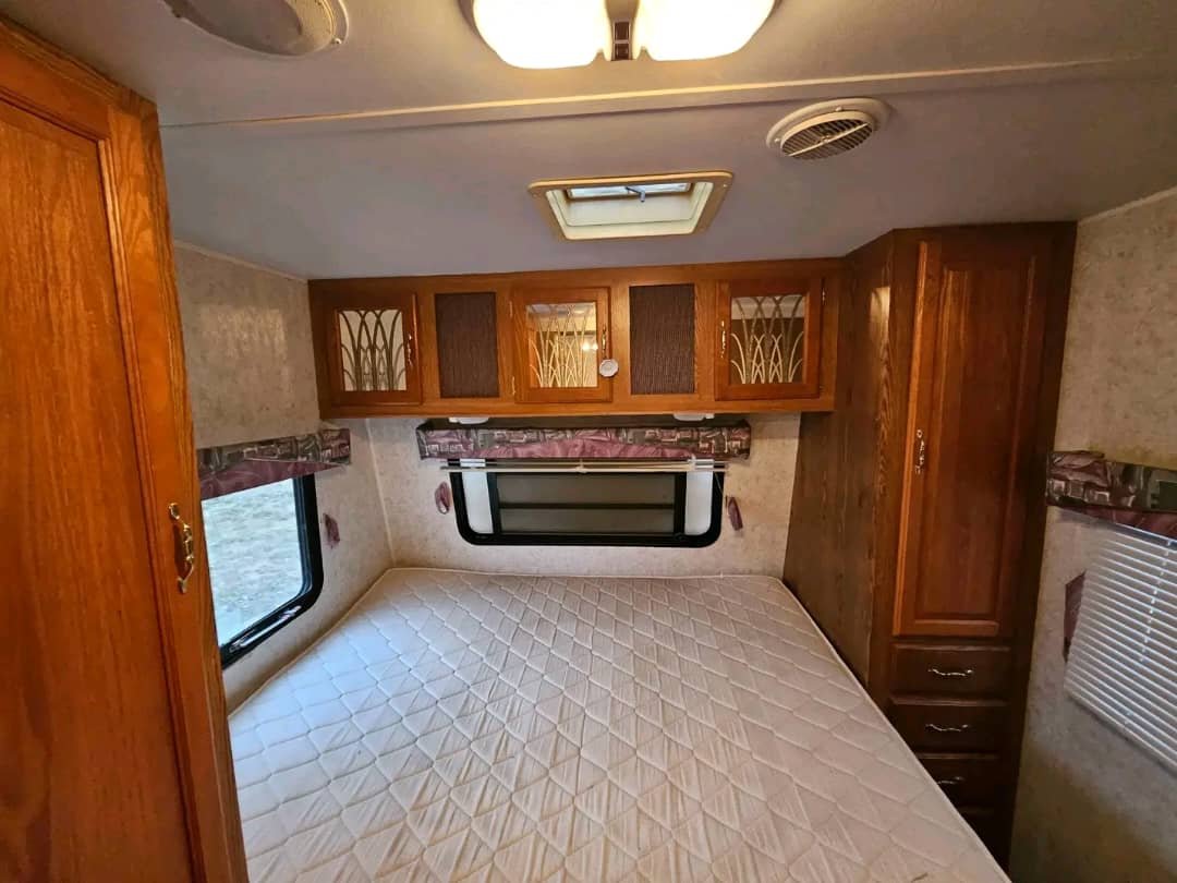Queen pillowtop mattress in the master bedroom of the Wildwood 32ft trailer.