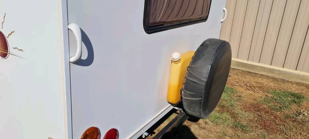 Rear exterior view of caravan with mounted spare tire
