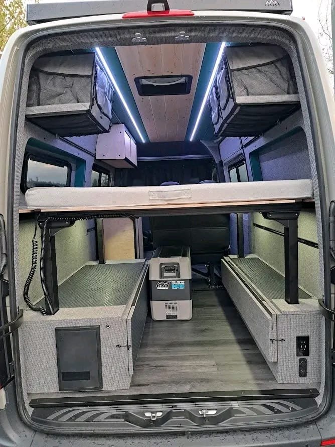 Upper bed deployed inside Mercedes-Benz Sprinter camper