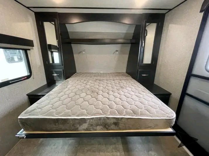 Queen size bed inside Grand Design Imagine XLS travel trailer