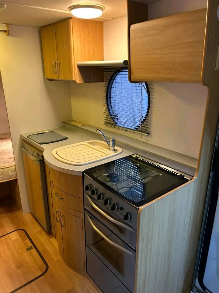 Kitchen sink with storage and overhead cabinets in Avondale Bianco caravan